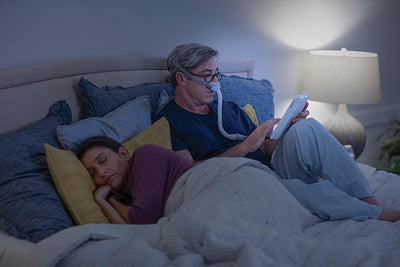 Man reading in bed wearing the AirFit™ N30 mask