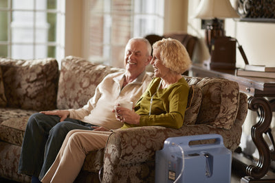 Couple sitting on couch laughing with EverFlo sitting next woman