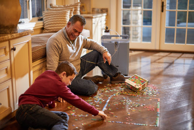 Man using the Everflo while doing a puzzle with his son