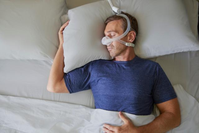 Man sleeping on his back wearing nasal mask
